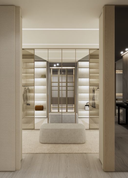 Luxury walk-in closet at Williams Island Residence featuring illuminated glass shelving, built-in storage, a central upholstered bench, and a modern minimalist design. Design by Troy Dean Home.